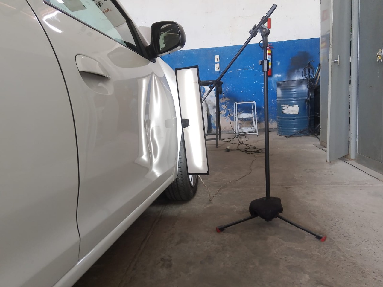 Lateral de veículo sendo analisada com luz de inspeção